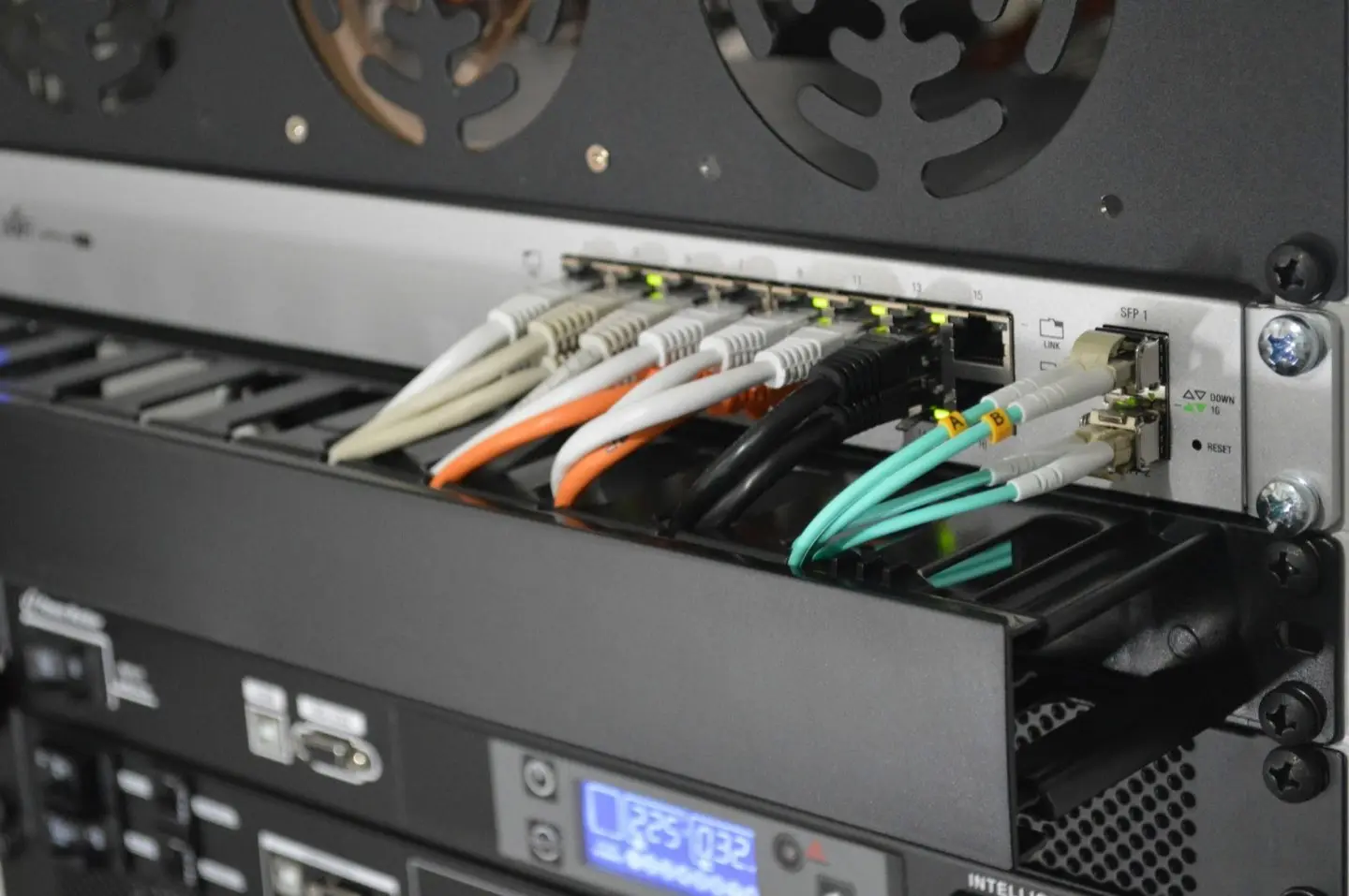 Network switch in a rack with coloured patch cables – technology building blocks, added individually